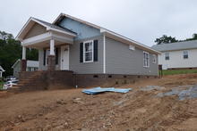 House missing siding on the top of the front wall. 